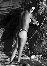 Nikki strips off naked in a spanish beach exposing her nice tits and give her dick a splash